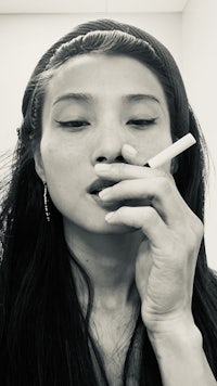 a woman is smoking a cigarette