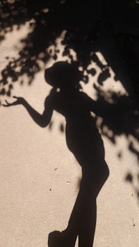 a shadow of a woman on a sidewalk